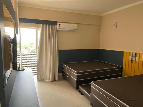 a hospital room with two beds and a window at Spazzio Diroma - Hospedagem com Acqua Park (Parque do Vulcão) in Caldas Novas