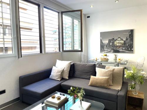 a living room with a blue couch and windows at Impecable, nuevo, cómodo, frente al metro Colombia in Madrid