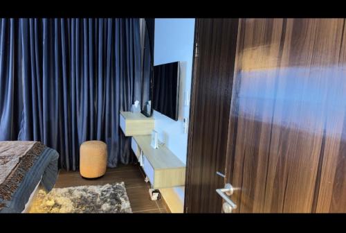 a bedroom with a bed and a mirror and a curtain at Bogotá by Homefront Encanto in Abuja