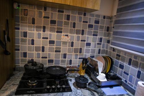 a kitchen with a stove and a sink with a mixer at Bogotá by Homefront Encanto in Abuja