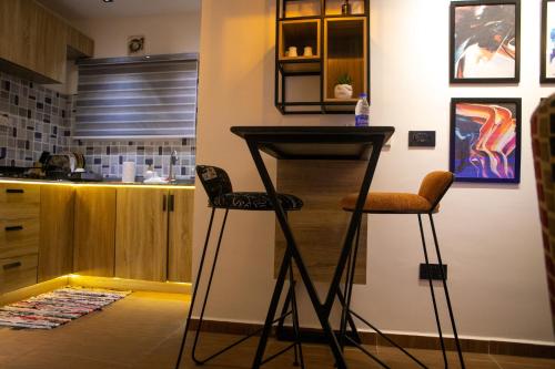 a bar in a kitchen with two stools at Bogotá by Homefront Encanto in Abuja