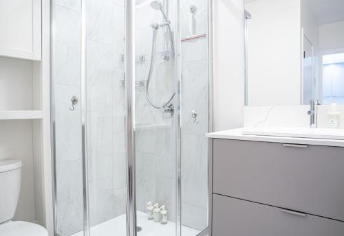 a white bathroom with a shower and a toilet at Wildflower Retreat by Revelstoke Vacations in Revelstoke