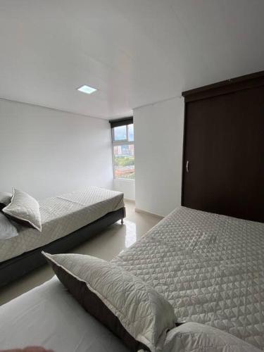 1 dormitorio con 2 camas y ventana en Pent House De Lujo 901, en Medellín