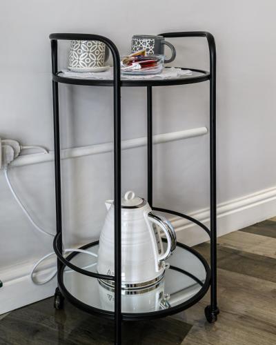 a black shelf with a tea kettle and dishes on it at Modern and Stylish 1-Bedroom Guesthouse near M6 J10 Perfect for Business Stays & Couples Free Parking & Wi-Fi in Willenhall