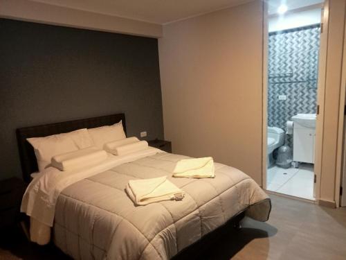a bedroom with a bed with two towels on it at Mmarros Inn in Cusco
