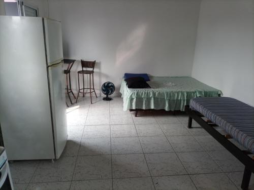 SolemarにあるRecanto da paz 2のベッドと冷蔵庫が備わる客室です。