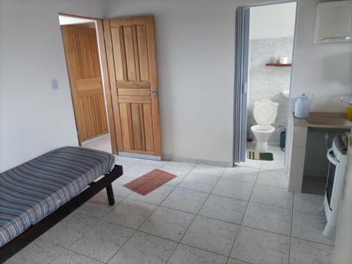Habitación con puerta que da a un baño con aseo. en Recanto da paz 2, en Solemar