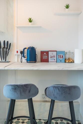two blue stools sitting under a counter in a kitchen at Brick Lane Hub in London