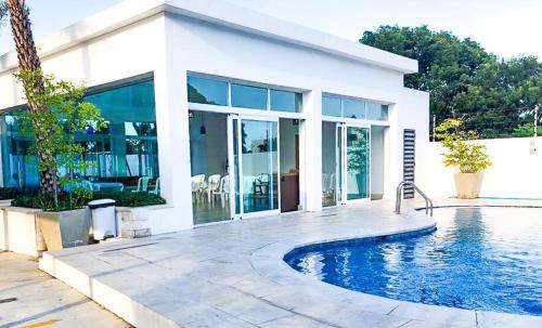 une maison avec une piscine en face de celle-ci dans l'établissement Luxe Living Spacious Retreat Torre Real Ii, à Santiago de los Caballeros
