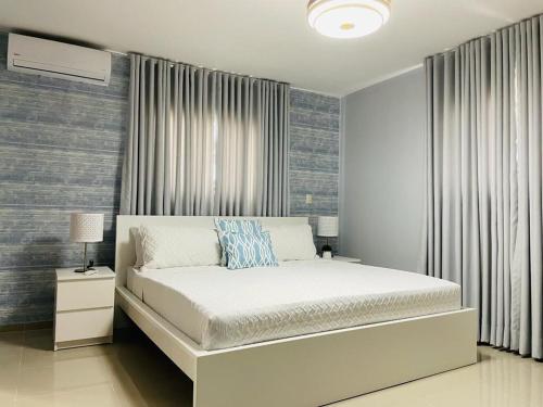 聖地亞哥洛斯卡巴的住宿－Harmony 2 Santiago，卧室配有白色的床和窗户。