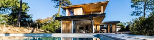 una casa con piscina frente a ella en SPRING KEYWEEK - Contemporary villa with pool in the hea, en Anglet