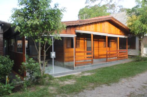 a wooden house with glass doors in a yard at Pousada e Camping Carrion in Itu