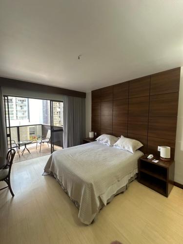 een slaapkamer met een groot bed en een groot raam bij Kubitschek Plaza Hotel - flat particular in Brasilia