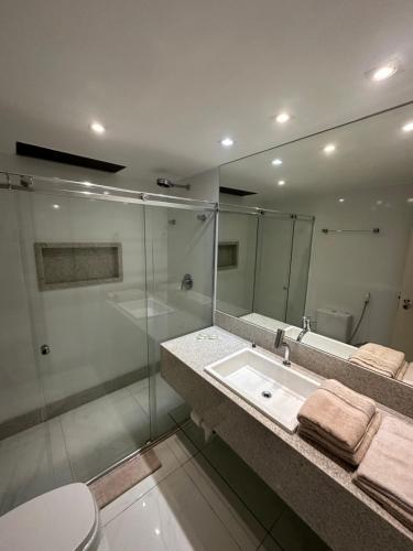 a bathroom with a shower and a sink and a mirror at Kubitschek Plaza Hotel - flat particular in Brasilia