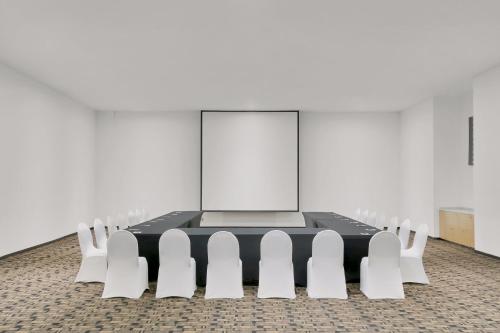 a conference room with a table and white chairs at Fiesta Inn Insurgentes Sur in Mexico City