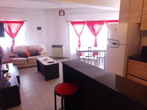 cocina y sala de estar con sofá y mesa en Departamento en Comodoro Rivadavia