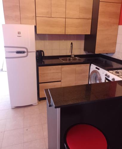 cocina con nevera blanca y lavadora en Departamento en Comodoro Rivadavia