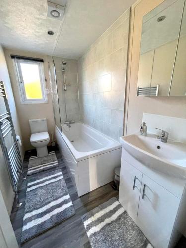 a bathroom with a tub and a sink and a toilet at Lone Star Lodge in Morpeth