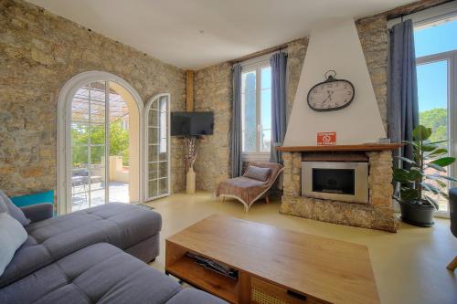 un salon avec un canapé et une cheminée dans l'établissement IMMOGROOM - T3 - Garden - Quiet - Air conditioning, à Cannes