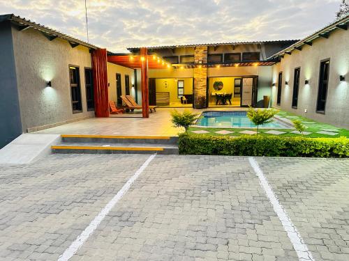 a house with a courtyard with a swimming pool at Signature Boutique Guesthouse in Maun