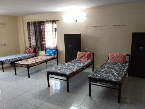 a waiting room with three chairs and a table at GharApna Hostel in Mumbai