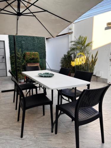 einen weißen Tisch und Stühle auf einer Terrasse in der Unterkunft Mar y Tierra in Manta