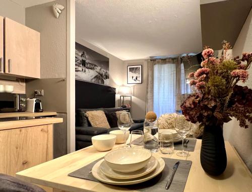 a kitchen with a table with plates and a vase of flowers at Rocky Studio Chamonix Sud in Chamonix-Mont-Blanc