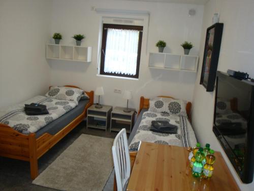 a room with two beds and a table and a dining room at Cenet 1 Zimmer Apartment in Sindelfingen