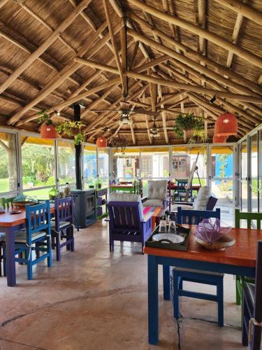 un restaurante con techos de madera, mesas y sillas en Quinta Loma Alta en Capilla del Señor