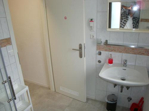 a person taking a picture of a bathroom with a sink at Cenet 1 Zimmer Apartment in Sindelfingen