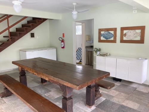 a dining room with a wooden table and a staircase at Casa em condomínio fechado - Praia de Itaguaré in Bertioga