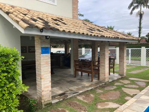 a patio with a roof on top of a house at Casa em condomínio fechado - Praia de Itaguaré in Bertioga