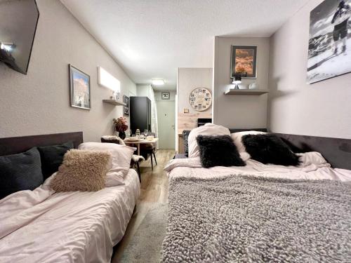 ein Wohnzimmer mit 2 Betten und Kissen darauf in der Unterkunft Rocky Studio Chamonix Sud in Chamonix-Mont-Blanc