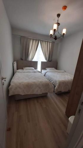 1 dormitorio con 2 camas y ventana en First Avenue AVM Residences, en Büyükçekmece