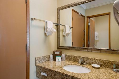 W łazience znajduje się umywalka i lustro. w obiekcie Best Western Holiday Hotel w mieście Coos Bay