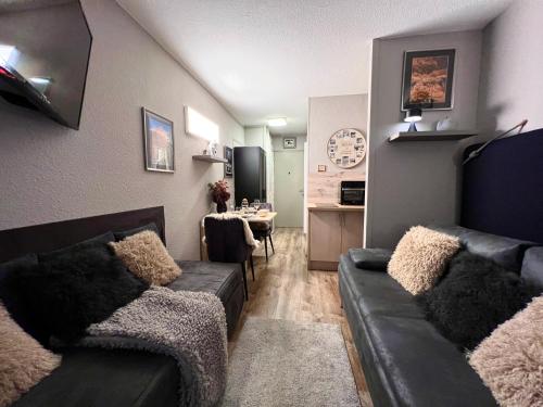 a living room with a couch and a dining room at Rocky Studio Chamonix Sud in Chamonix-Mont-Blanc