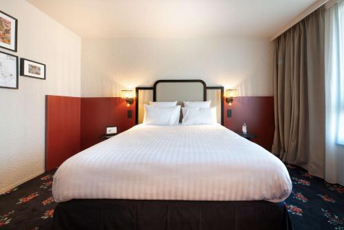 a large white bed in a hotel room at Best Western Porte du Forez in Andrézieux-Bouthéon