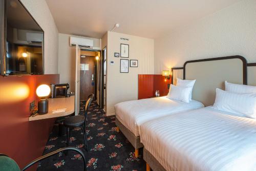 a hotel room with two beds and a mirror at Best Western Porte du Forez in Andrézieux-Bouthéon