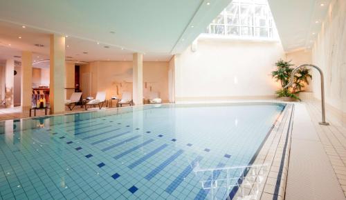 a large swimming pool in a building with a large window at Dorint Strandhotel Binz/Rügen in Binz