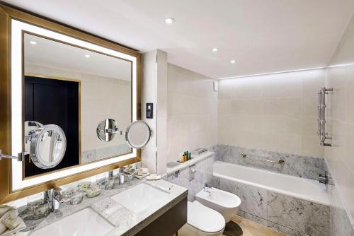 La salle de bains est pourvue d'un lavabo, de toilettes et d'une baignoire. dans l'établissement Hilton Budapest, à Budapest