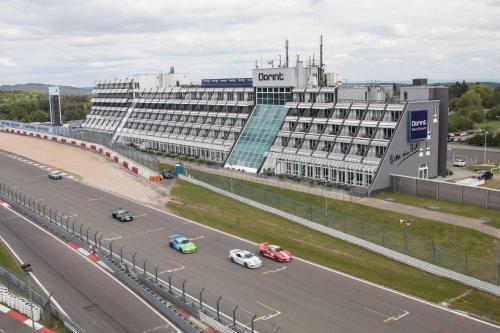 ein großes Gebäude mit Autos, die auf einer Autobahn fahren in der Unterkunft Dorint Am Nürburgring Hocheifel in Nürburg