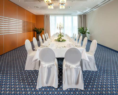 a conference room with a long white table and chairs at Dorint Am Nürburgring Hocheifel in Nürburg