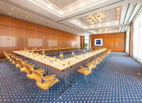 ein großer Konferenzraum mit einem langen Tisch und Stühlen in der Unterkunft Dorint Am Nürburgring Hocheifel in Nürburg