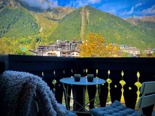 a table on a balcony with a view of mountains at Rocky Studio Chamonix Sud in Chamonix-Mont-Blanc