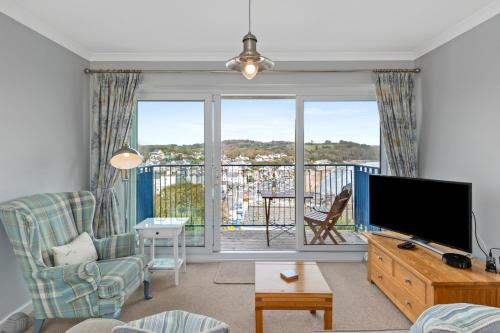 a living room with a tv and a large window at Brynawelon - Wonderful Sea and Harbour Views in Saundersfoot