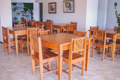 comedor con mesas y sillas de madera en Ilha1 - Condominio Marinas Do Canal en Cabo Frío