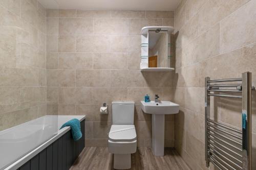 ein Badezimmer mit einem WC, einem Waschbecken und einer Badewanne in der Unterkunft Sea Urchins - Sea Front Apartment with Views in Saundersfoot