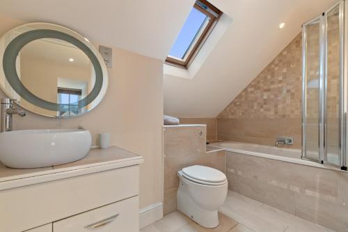 a bathroom with a sink toilet and a mirror at Park Place Court - Close to Beach with Parking in Tenby