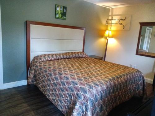 1 dormitorio con 1 cama en una habitación con lámpara en Maple leaf motel en New Milford