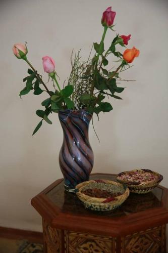 a vase with roses in it sitting on a table at RIAD GREEN LOTUS in Marrakech